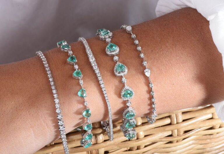 joias para usar nas festas de fim de ano - modelo veste conjunto de pulseiras em ouro branco, diamantes brancos e esmeraldas